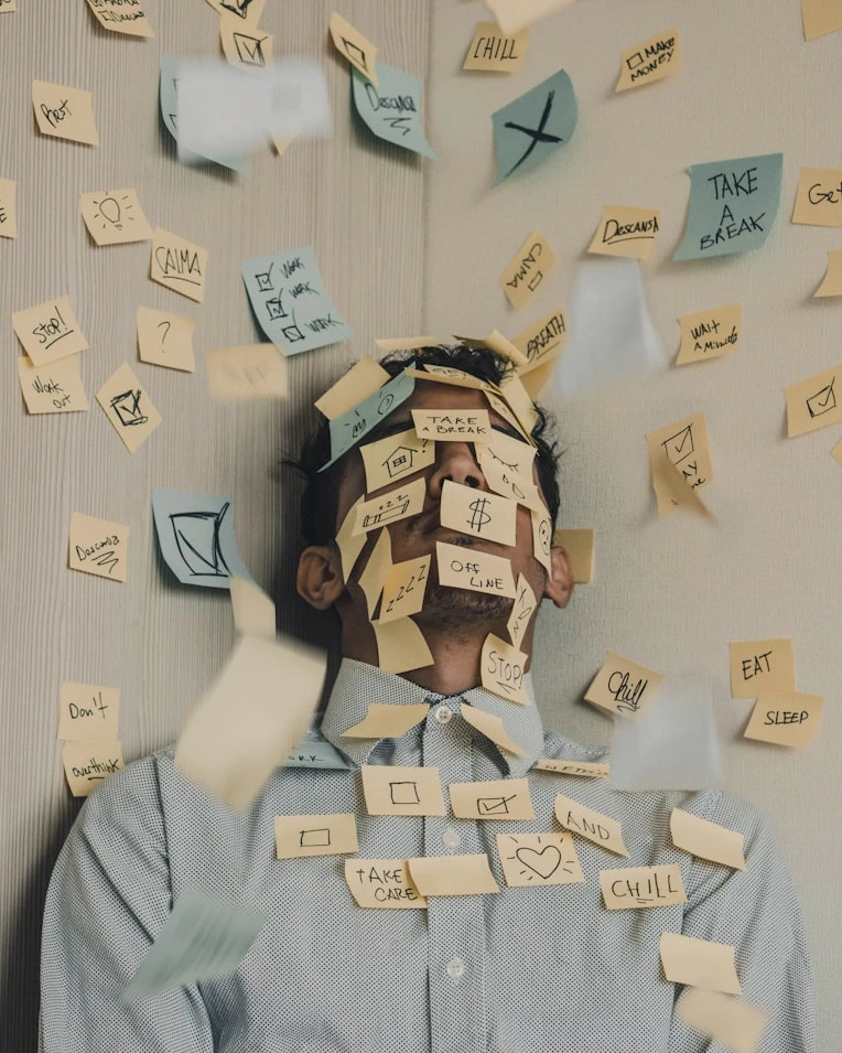 homme dépassé par le nombre de post-it sur lui