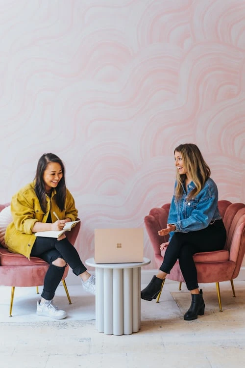 meeting commercial entre deux femmes souriantes