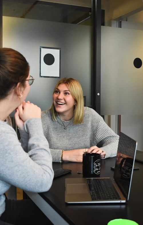 meeting commercial entre deux femmes souriantes